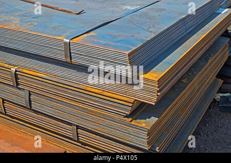 Il Rusty laminati a caldo di metallo di foglio in confezioni presso il magazzino di prodotti metallici impilati all'aria aperta Foto Stock