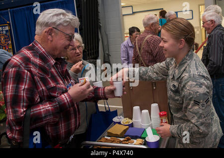 Airman 1° classe Staffen Allie, 91Missile squadrone manutenzione impianti sezione manutenzione tecnico, offre spuntini per i cittadini pensionati al saluto annuale per gli anziani evento in Minot, N.D., 9 maggio 2017. Minot Air Force Base ha aiutato i volontari con sicurezza, che serve cibo e bevande, distribuendo regali e scortare i cittadini anziani di aree designate. Foto Stock