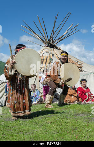L uomo e la donna in abbigliamento nazionale aborigeno della Kamchatka espressione ballando con un tamburello. Concerto pubblico folklore nazionale gruppo di danza Foto Stock