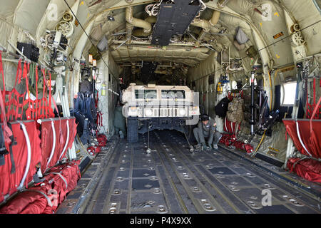 HUNTER LIGGETT, California (9 maggio 2017) - aviatori assegnati al 146aria parafango sollevamento della Air National Guard prepararsi a scaricare un Humvee assegnato alla Naval Mobile Battaglione di costruzione (NMCB) 4 durante una formazione sul campo di allenamento (FTX) in Fort Hunter Liggett, California, 9 maggio. NMCB 4 sta conducendo il loro ultimo classificato la formazione sul campo di allenamento (FTX), prove il battaglione di comando, controllo e le funzioni di comunicazione attraverso una varietà di simulazione di scenari di vita reale incontrate durante le distribuzioni. Il battaglione Seabee fornisce dei comandanti e dei Navy comandanti del componente con il combattimento pronto warfighter capa Foto Stock