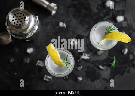 Cocktail alcolici con limone e rosmarino e ghiaccio. Il gin tonic fizz o succhiello cocktail su sfondo nero, copia dello spazio. Foto Stock