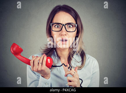 Scioccato young business woman ricevere cattive notizie per telefono Foto Stock