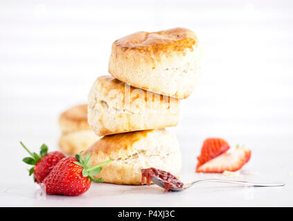 Tè alla crema - scones con marmellata, crema e fragola è su sfondo bianco Foto Stock