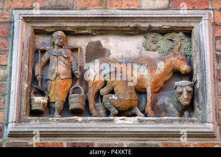 BELGICA. BRUJAS. Scaricare en la fachada de una casa con la rappresentazione de onu campesino ordeñando n.a. vaca. Provincia de Flandes Occidental. Foto Stock