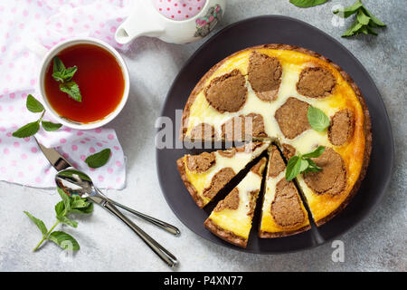 Cheesecake e tè alla menta cup. Il cioccolato New York cheesecake e tè alla menta cup su sfondo di calcestruzzo. Foto Stock