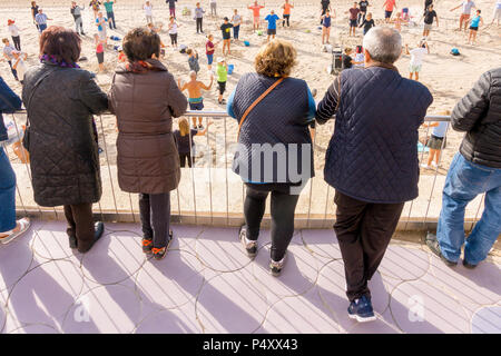 Le persone anziane guarda come active seniors stanno facendo esercizi sportivi sulla Spiaggia di Benidorm Spagna Foto Stock