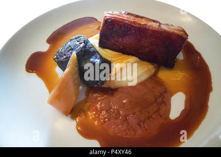 Studio shot di carne di maiale alla griglia la pancia e black pudding isolato su bianco - Giovanni Gollop Foto Stock