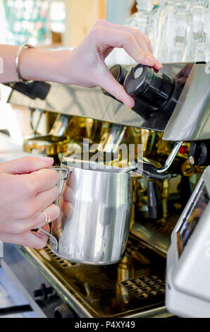 Barista ragazza infusi espressoo una sola tazza utilizzando delle macchine per caffè professionali in un cafe Foto Stock