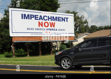 Florida, Stati Uniti d'America. Il 23 giugno 2018. Una macchina passa un cartellone a Lakeland, Florida il 23 giugno 2018 chiamando l'impeachment di U.S. Presidente Donald Trump. Il cartello stradale è stato recentemente collocato su una strada parallela al percorso pesantemente I-4 da Mad Dog PAC, un Maryland basata su gruppo progressiva, come parte di una campagna nazionale dedicata al finanziamento di cartelloni targeting Trump e altri politici del GOP. Il gruppo collocato un tabellone identico all' inizio di quest' anno a due miglia da Trump's Mar-a-Lago estate in Palm Beach, Florida. (Paul Hennessy/Alamy) Credito: Paul Hennessy/Alamy Live News Foto Stock