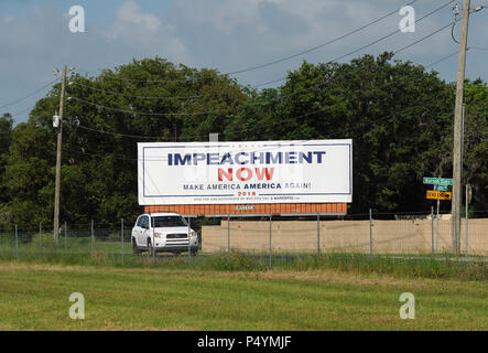 Florida, Stati Uniti d'America. Il 23 giugno 2018. Una macchina passa un cartellone a Lakeland, Florida il 23 giugno 2018 chiamando l'impeachment di U.S. Presidente Donald Trump. Il cartello stradale è stato recentemente collocato su una strada parallela al percorso pesantemente I-4 da Mad Dog PAC, un Maryland basata su gruppo progressiva, come parte di una campagna nazionale dedicata al finanziamento di cartelloni targeting Trump e altri politici del GOP. Il gruppo collocato un tabellone identico all' inizio di quest' anno a due miglia da Trump's Mar-a-Lago estate in Palm Beach, Florida. (Paul Hennessy/Alamy) Credito: Paul Hennessy/Alamy Live News Foto Stock