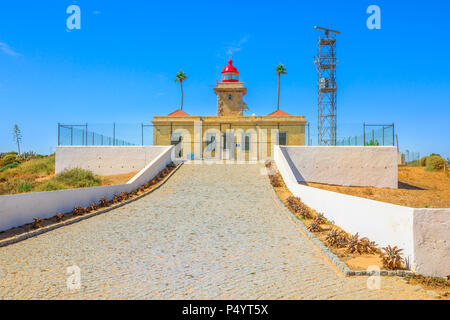 Vista frontale di architettura di Lagos faro o Farol Ponta da Piedade in cima le scogliere spettacolari di Ponta da Piedade. Lagos in Algarve, Portogallo, Europa. Giornata soleggiata con cielo blu. Foto Stock