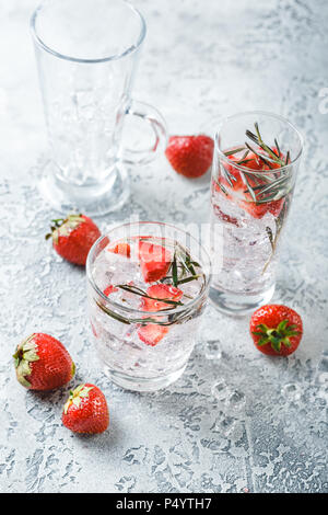 Alcolico o analcolico aperitivo con fragole e rosmarino e ghiaccio in bicchieri di vetro Foto Stock