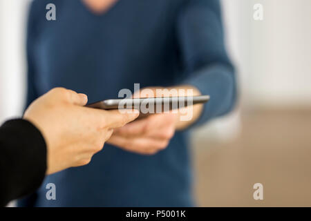 Le mani di un uomo e di una donna che mantiene tavoletta digitale Foto Stock