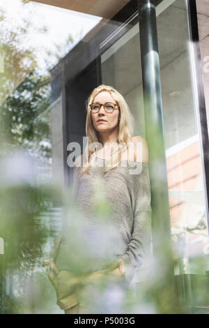 Ritratto di bionda donna matura permanente sulla terrazza Foto Stock