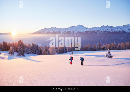 Austria, Tirolo, giovane con le racchette da neve a sunrise Foto Stock