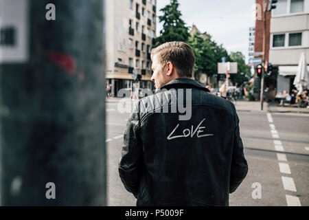 Vista posteriore del giovane vestita di nero giacca di pelle con la scritta 'amore' Foto Stock