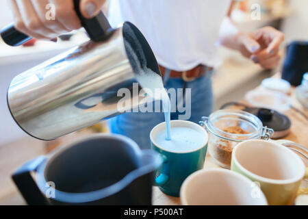 Close-up di donna versando bevanda in tazza Foto Stock