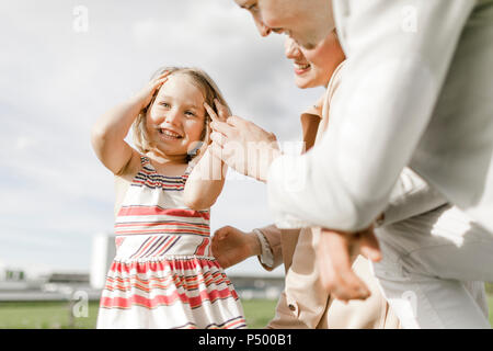 Ritratto di felice bambina con i suoi genitori all'aperto Foto Stock