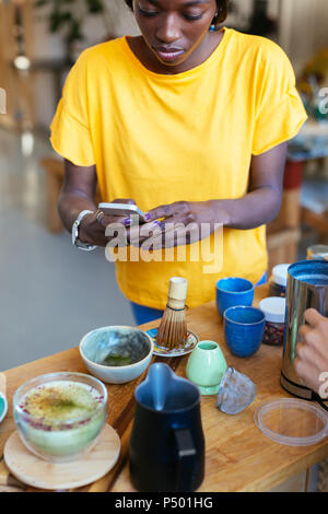 Donna prendendo immagini dello smartphone in cucina Foto Stock