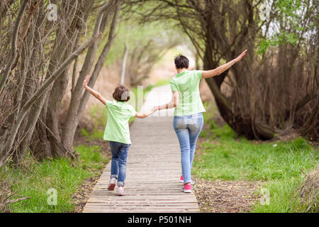 Vista posteriore della madre e figlia camminando mano nella mano sul lungomare Foto Stock