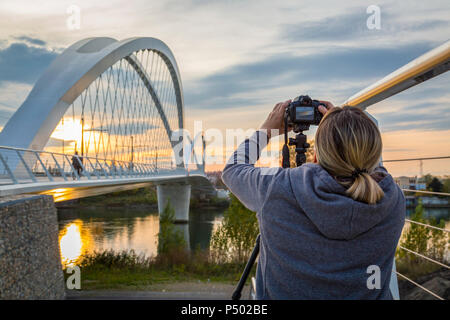 Francia, Alsazia, Strasburgo, Passerelle des Deux Rives al tramonto, femmina fotografo in primo piano Foto Stock