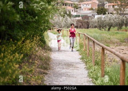 Madre e figlia in esecuzione su un percorso in ambiente naturale Foto Stock