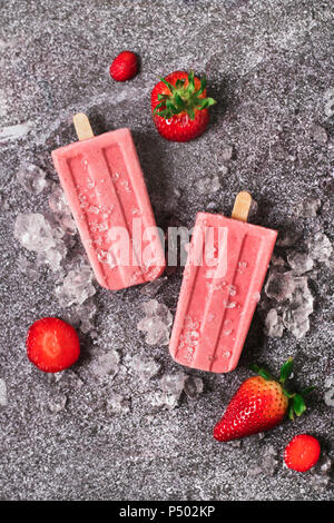 Due fatti in casa fragola ghiaccioli, ghiaccio e fragole su marmo Foto Stock