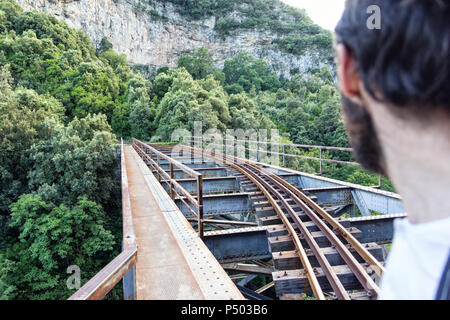 La Grecia, Pilion, Milies, uomo guardando i binari della ferrovia a scartamento ridotto Foto Stock