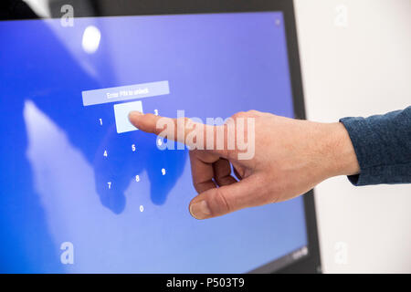 Imprenditore immettendo il codice PIN sul touch screen Foto Stock
