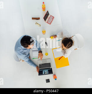 Due persone di affari al tavolo riunione in ufficio, vista dall'alto Foto Stock