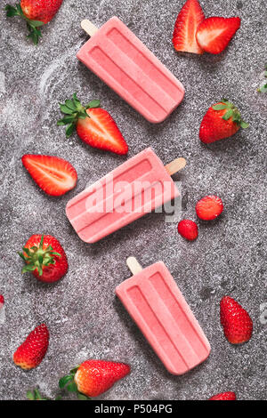 Tre in casa fragola ghiaccioli e fragole su marmo Foto Stock