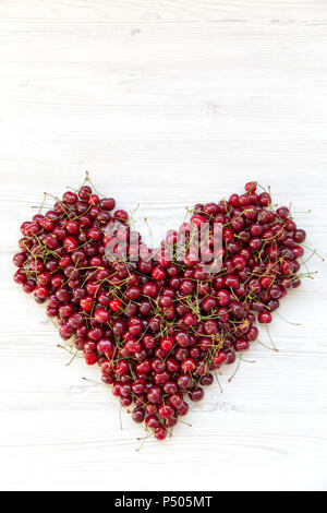 Fresche ciliege dolci a forma di cuore, vista dall'alto. Lay piatto. Copia dello spazio. Foto Stock