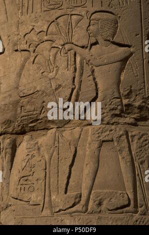 Arte Egizia. Rilievo raffigurante un faraone facendo un offerta di fiori di papiro agli dèi. Primo cortile di Ramses II. Tempio di Luxor. Dinastia XIX. Nuovo Impero. Foto Stock