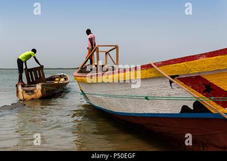 Cacheu, Repubblica di Guinea Bissau - 1 Febbraio 2018: i pescatori preparano le loro canoe nel porto della città di Cacheu in Guinea Bissau. Foto Stock