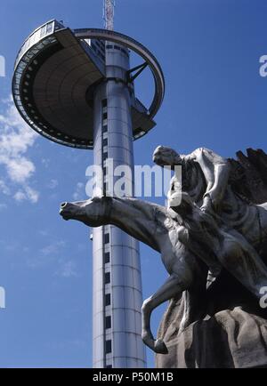 FARO DE LA Moncloa. Torre de iluminación y Comunicaciones, construida para conmemorar el nombramiento de la ciudad como Capitale Europea de la Cultura en el año 1992. Mide 92 m. de altura y está situado en la Ciudad Universitaria. En primer término, unà ESCULTURA. MADRID. España. Foto Stock