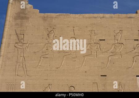 Tempio di Horus. Il faraone prima gli dèi. Ingresso principale. Primo pilone. Dettaglio. Edfu. L'Egitto. Foto Stock