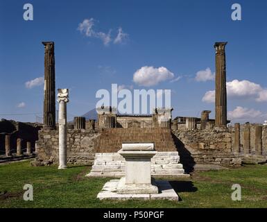 L'Italia. Pompei. Tempio di Apollo. Il marmoreo altare e colonna ionica costruito per tenere la meridiana. In background. scale e due colonne corinzie scanalate. Foto Stock