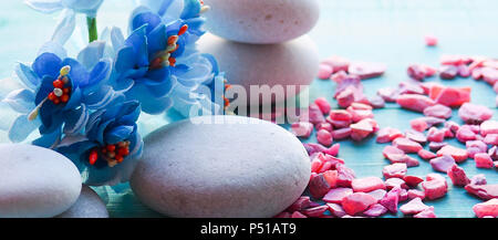 Composizione Spa di candele blu, pietre su sfondo blu Foto stock - Alamy