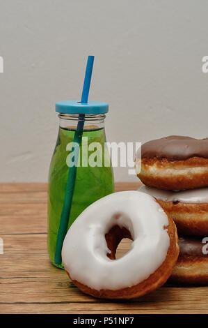 Una pila di ciambelle e una bottiglia di bevanda fresca Foto Stock