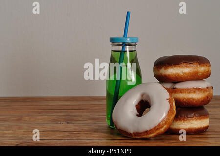 Una pila di ciambelle e una bottiglia di bevanda fresca Foto Stock