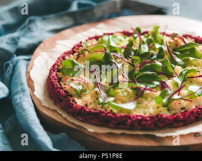 La barbabietola rossa crosta di pizza con un fresco e bietole o mangold, barbabietole rosse foglie. Idee e ricette per piatti vegan snack.Egg-free crosta di pizza con chia semi e cereali integrali farina di riso. Copia dello spazio. DOF poco profondo Foto Stock