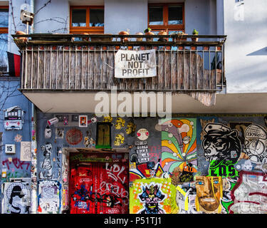 Berlino,Friedrichshain-Kreuzberg, Intimes Cinema. Graffiti-facciata coperta di Art-House movie theater & appartamento balcone con "il pianeta non profit poster Foto Stock