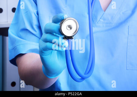 Closeup ritratto di un medico con uno stetoscopio su uno sfondo di un ripiano con le cartelle. Foto Stock