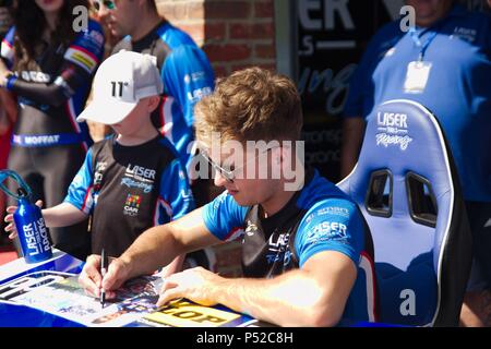 Dalton on Tees, Inghilterra, 24 giugno 2018. Dunlop MSA British Touring Car Championship conducente Aiden Moffat firma autografi per gli spettatori durante un pit a piedi sul circuito di Croft. Credito: Colin Edwards/Alamy Live News. Foto Stock