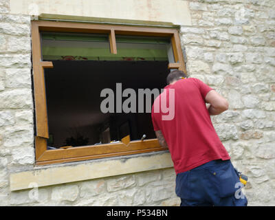 Finestra montatore di sostituire il vecchio con vetri doppi uPVC serramenti con nuovo solida quercia triplo vetro telai di finestra Foto Stock