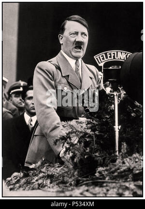 Discorso di Adolf Hitler del 1930, in uniforme militare, con Telefunken radio Microphone che trasmette alla Nazione tedesca in piedi sul podio della piattaforma degli oratori in un raduno del partito nazista a Norimberga in Germania Foto Stock