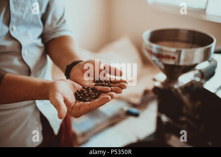 Professional la tostatura del caffè e il test con la mano in Colombia Foto Stock