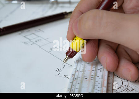 Ingegnere tecnico tenendo la penna e funziona su una mano disegnato il disegno tecnico, sliderule Foto Stock