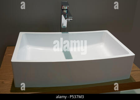 Top bianco rectangukar ceramica lavabo e metallo lucido montato a parete miscelatore Foto Stock
