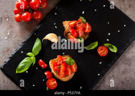 Antipasto Italiano chiamato Bruschetta condito con pomodoro, aglio e basilico - vista superiore Foto Stock